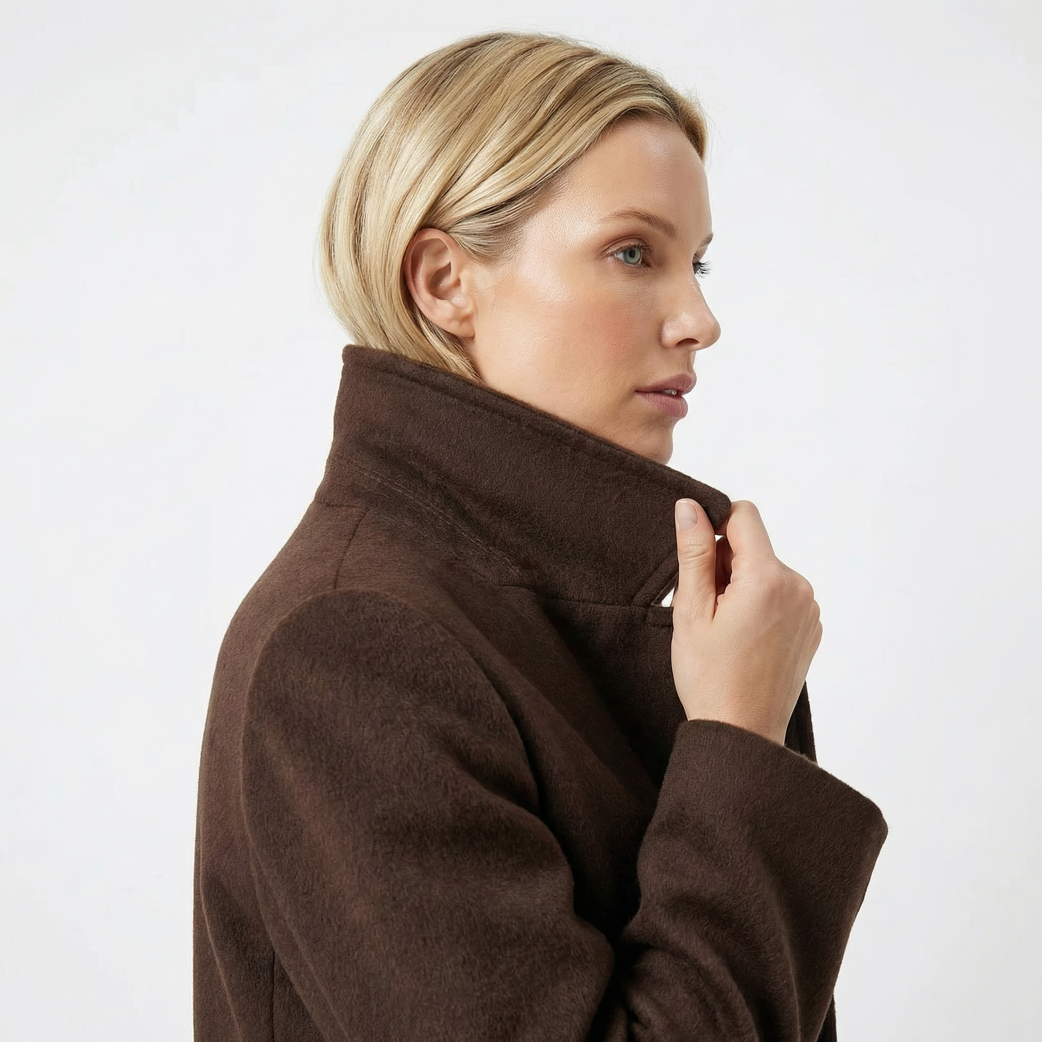 Woman in side view wearing a high-collared brown wool winter coat